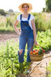 © nenetus - Beautiful young smiling woman holding basket with fresh vegetables from the garden looking at the camera.