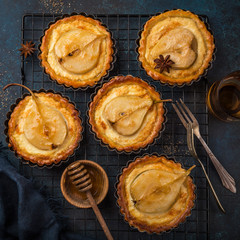 pear and custard tarts on dark blue background