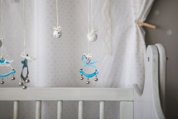 small toys hanging above baby cot