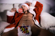 © Tony Marturano - Sexy, naked male Santa with open jacket revealing pecs and six pack, licking a lollipop with candy filled stocking in between his legs