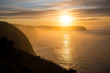 Sunrise above coastline cliffs with fog