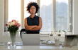© Jacob Lund - Confident young businesswoman standing at her desk