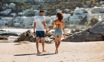 Couple walking on beach holding hands