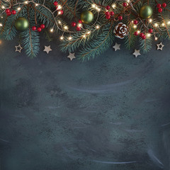 Christmas background with fir twigs, red berries, cones and Xmas lights on dark, copy-space