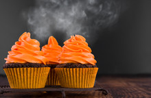 Festive Close-up View Of Decorative Homemade Halloween White And Orange Frosted Cupcakes With Eyes On Black Background. Text Space Concept.