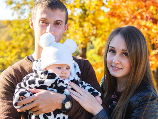 Smiling mother and father of a newborn baby . In autumn Park