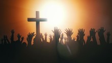Silhouettes Of Hands Raised In Worship With Light Rays And Cross.