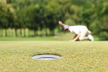 Wall Mural - Man golfer check line for putting golf ball on green grass