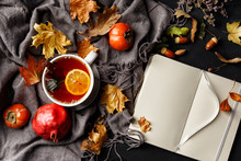Autumn Composition. A Cup Of Fragrant Tea With Lemon On A Dark Table With Autumn Leaves And Flowers.