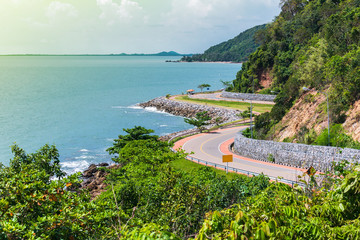 Wall Mural - Road beside the ocean and mountain under blue sky