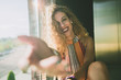 © ADDICTIVE STOCK - Content woman outstretching hand at camera in sunlight