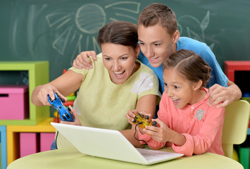 Wall Mural - portrait of young mother with children playing computer game wit