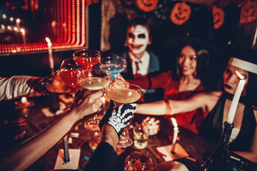 closeup young people in costumes clinking glasses