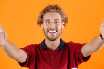 Sticker - Handsome young man laughing and taking selfie on color background