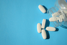 Sugar Pills, Artificial  Sweeteners. Close Up White Pills With A Bottle On A Blue Background