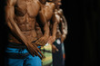 group athletes bodybuilders in colorful summer shorts at competitions in beach bodybuilding