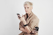 © olgapogorelova - Portrait of blond caucasian woman emotion drinks takeaway coffee, using smartphone on white background.