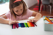 © Kinzie+Riehm - A child lines up colorful crayons in a row.