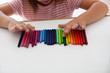 © Kinzie+Riehm - A child lines up colorful crayons in a row.