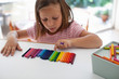 © Kinzie+Riehm - A child lines up colorful crayons in a row.