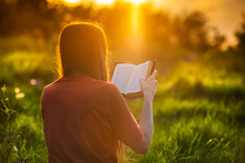 Girl Reading The Bible At Sunset