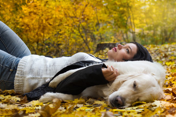 Portrait of happy woman with dog in autumn park.