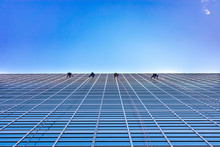 Four Window Washers Cleaning On The Side Of A Skyscraper Looking Up