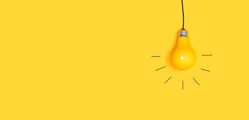 Wall Mural - one hanging light bulb on a yellow background