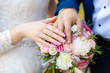 Hands of bride and groom on wedding bouquet. Marriage concept