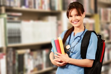 Wall Mural - Attractive young female doctor student on background