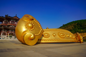 Wall Mural - a golden wishful sculpture placed in front of the temple