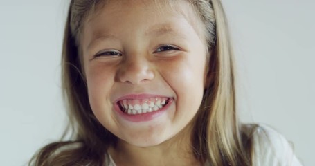 close up of a smiling blond little girl (kid) on white background.