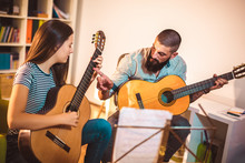 Guitar Teacher Teaching The Girl At Home.