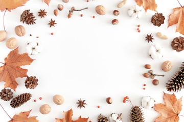 Wall Mural - Autumn composition. Frame made of orange leaves, cotton flowers, pine cone, anise star, berries, nuts on white background. Autumn, fall concept. Flat lay, top view, copy space 