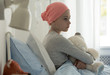 © Photographee.eu - Sick child with cancer sitting in hospital bed holding teddy bear