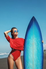 Wall Mural - Sexy woman surfer with shortboard on the beach