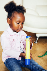 little cute african american girl playing with animal toys at ho