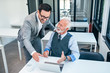© bnenin - Senior boss happy for good online work result of young male businessman.