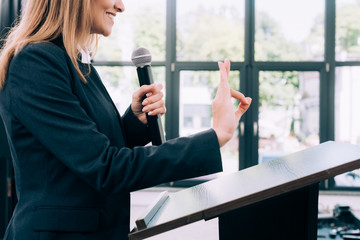 cropped image of lecturer showing okay gesture at podium tribune during seminar in conference hall