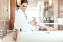 Woman In Luxurious Hotel Bathroom Letting Water In The Bathtub In Animation Of A Relaxing Experience 