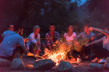 Young Friends Relaxing Around Campfire