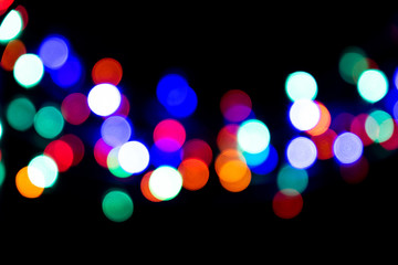 Poster - The colorful bokeh on the blurred natural black background.