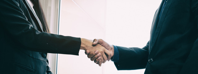 The abstract art design background of business workers are shaking hand,business hand sign of success,team work,collaborator,blurry light around