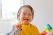 © Tierney - Happy toddler boy smiling while eating a meal