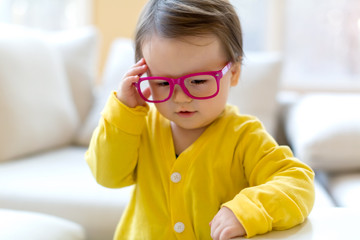 Wall Mural - Toddler boy with glasses playing in his house