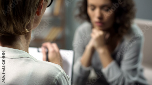 Cuadros en Lienzo Young depressed woman talking to lady psychologist during session, mental health