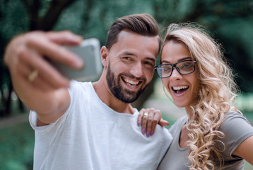 close up.smiling young couple taking selfie in city Park