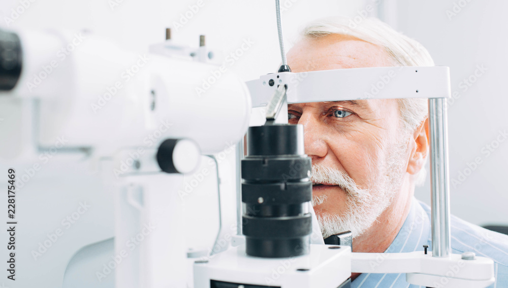 Senior patient checking vision with special eye equipment - obrazy, fototapety, plakaty 