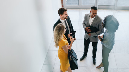 corporate professionals having casual meeting in office lobby