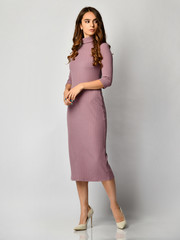 Young beautiful woman posing in new light purple fashion winter dress on high hills full body